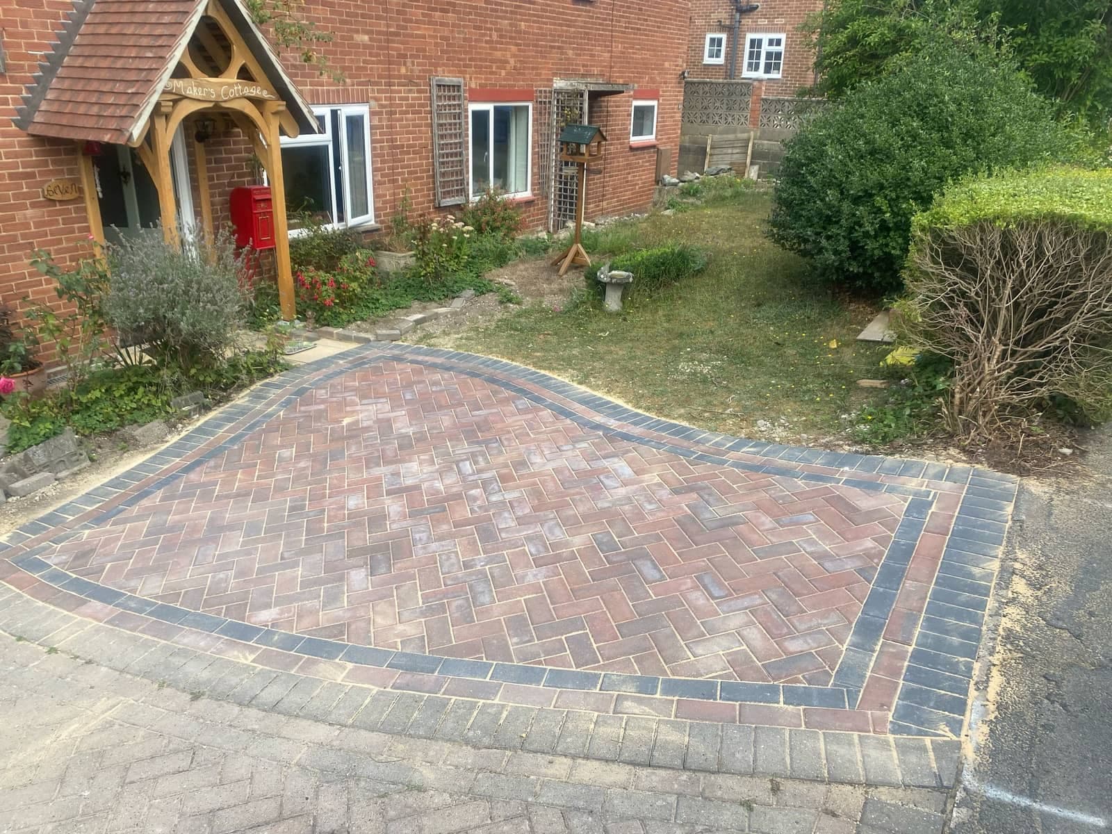 Block paved driveway outside a brick home
